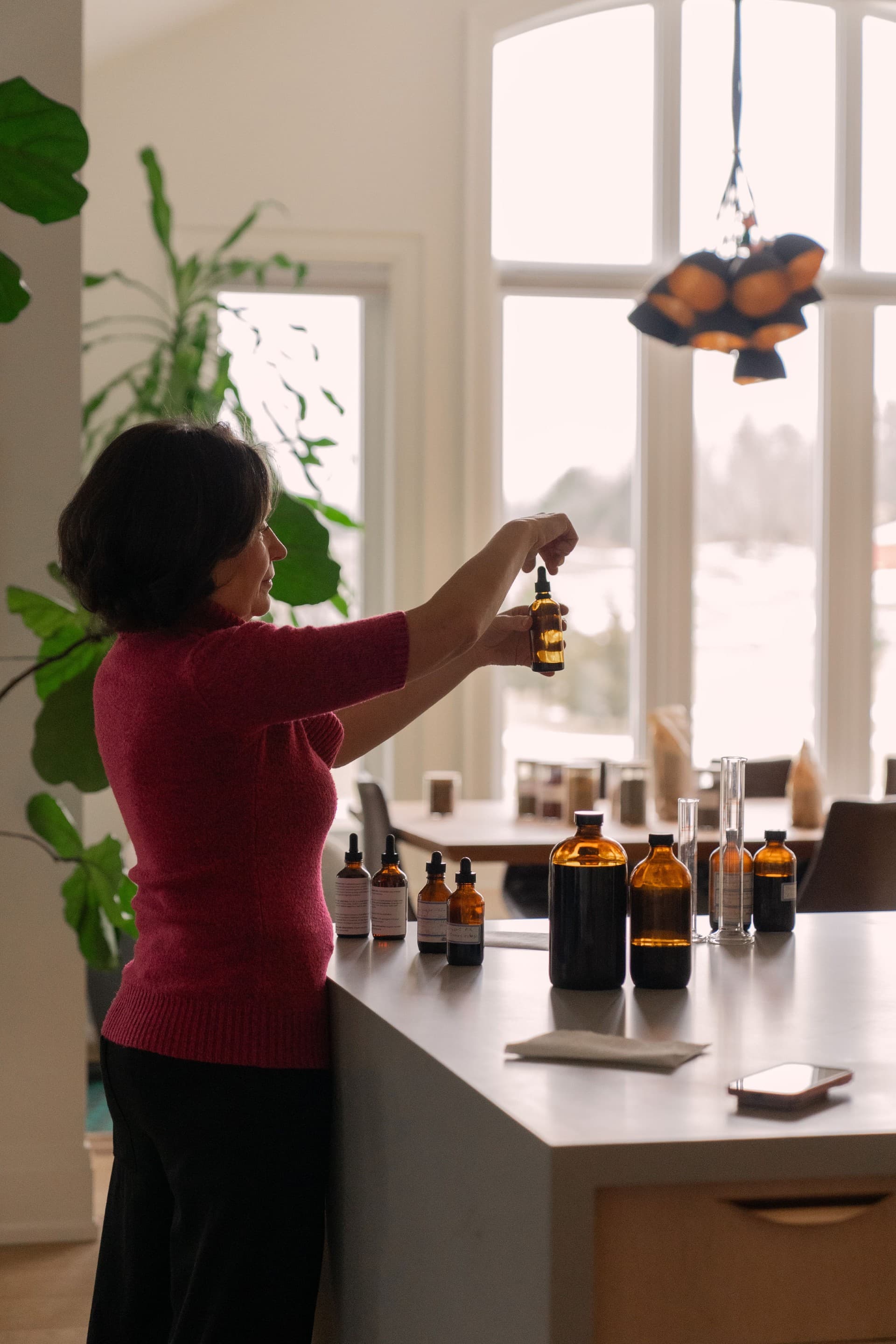 Marina preparing a botanical tincture at a work table